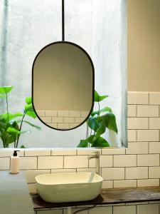 a bathroom with a round mirror and a sink at Heritage Vacation Inn Balcony in Kuching