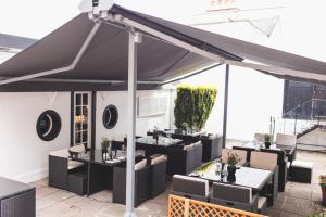 a black tent with tables and chairs on a patio at Old Court House Inn in Saint Aubin