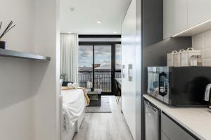 a kitchen with a bed and a view of a balcony at *One On Albert 511*Studio Apartment - Swimming Pool, WI-FI & Netflix* in Cape Town