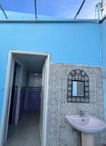 a bathroom with a sink and a mirror at Hôtel Restaurant Ali in Midelt