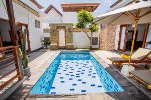 una piscina con azulejos azules en el suelo y una casa en Karang Island Villa, en Nusa Lembongan