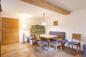 a dining room with a wooden table and chairs at Vitalhof am Kreischberg by ALPS RESORTS in Bodendorf