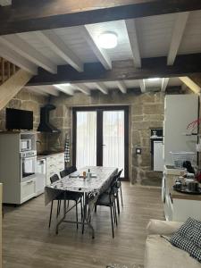 Una cocina con una mesa y sillas en una habitación. en Aturuxo VUT OR 994, en Trasmiras