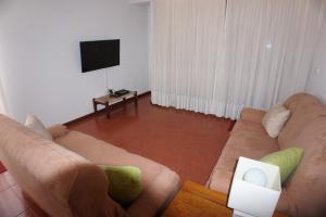 a living room with a couch and a television at !Your Home In Madeira in Funchal