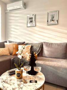 a living room with a couch and a table with wine glasses at Downtown Apartments Monroe in Rzeszów