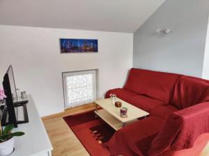 sala de estar con sofá rojo y mesa en Gîte Baldersheim, 4 pièces, 5 personnes - FR-1-744-6 en Baldersheim