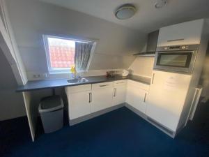 a small kitchen with a sink and a microwave at Hotel La Noire - Delft City Centre in Delft