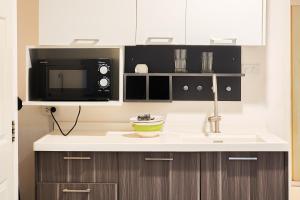 a kitchen with a sink and a microwave at Cordia Residence Sathorn in Bang Rak