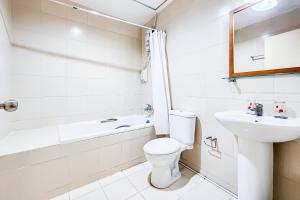 a white bathroom with a toilet and a sink at Cordia Residence Sathorn in Bang Rak