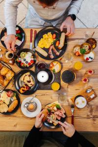 un grupo de personas sentadas en una mesa con alimentos para el desayuno en Pension Linder en Seeboden