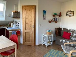 a living room with a kitchen and a door at Ferienwohnung Stockrose in Middelhagen