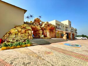 una facciata di un edificio con un mucchio di rocce di Wet n wild water park & resort a Mendarda