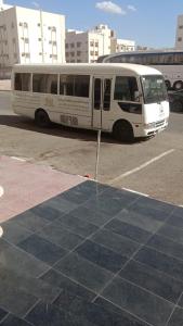a white bus is parked in a parking lot at فندق الاندلس الماسى in Al Madinah