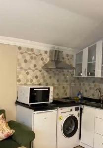 a kitchen with a washing machine and a microwave at Aygün Suites Hotel&Bungalow UZUNGÖL in Uzungöl