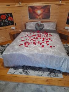 łóżko z czerwonymi różami w pokoju w obiekcie Nedleys Glamping w mieście Saint-Barbant
