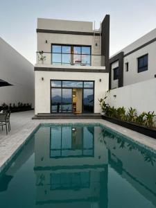 a house with a swimming pool in front of it at Sea Breeze Villa in Fujairah