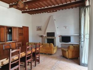 ein Wohnzimmer mit einem Tisch, Stühlen und einem Sofa in der Unterkunft Lampugnanino in Civitella Marittima