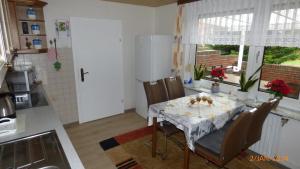 a kitchen with a table with chairs and a refrigerator at Ferienwohnung Hanne in Berumbur