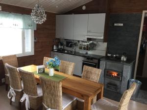 a kitchen with a wooden table with chairs and a fireplace at Nellim Holiday Home, Sámi Village in Nellimö