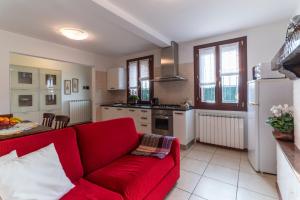 sala de estar con sofá rojo en la cocina en Casa Battaglia, en Cavallino-Treporti