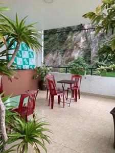 a patio with red chairs and a table in a building at Galaxy Home - Hotel Sky view in Cat Ba