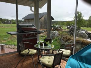 a patio with a table and chairs and a grill at Nellim Holiday Home, Sámi Village in Nellimö