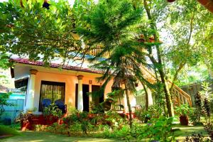 una casa con una palmera delante de ella en Marari John Villa, en Mararikulam