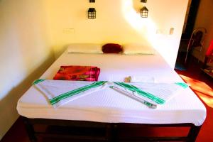 2 camas en una habitación con sábanas blancas en Marari John Villa, en Mararikulam