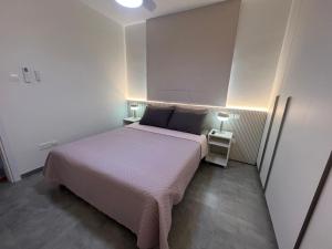 a small bedroom with a bed and two night stands at Johnny's luxury getaway in Strovolos