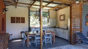 a kitchen with a wooden table and chairs in it at Vennebos cottages in Knysna