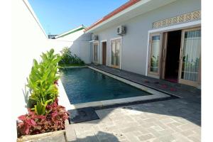 a swimming pool in front of a house at OYO 93508 Bale Jiwan Mukti Narmada in Narmada