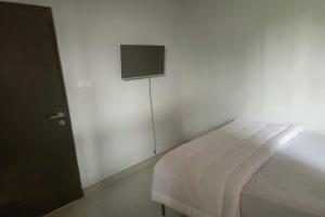 Purbolinggo的住宿－OYO 93514 Rubina Syariah Hotel，卧室配有一张床,墙上配有电视。