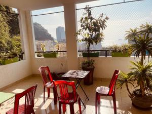 a room with red chairs and a table and windows at CatBa Sky View Hotel in Cat Ba
