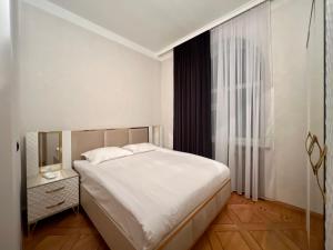 Un dormitorio con una gran cama blanca y una ventana en IT Hotel Yerevan, en Ereván
