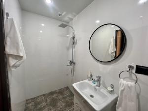 a white bathroom with a sink and a mirror at IT Hotel Yerevan in Yerevan