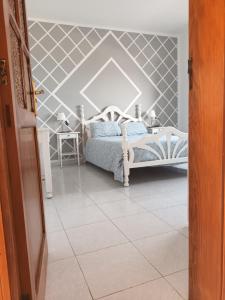 1 dormitorio con 1 cama con pared de acento geométrico en casa el lajiar, en Orzola