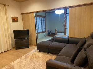 sala de estar con sofá y TV de pantalla plana en Lavender - Vacation STAY 26426v, en Nishina