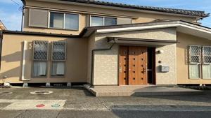 una casa con una puerta marrón y un camino de entrada en Lavender - Vacation STAY 26426v, en Nishina