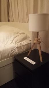 a lamp on a table next to a bed at Habitación en casco histórico in Seville