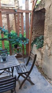 uma mesa de madeira e uma cadeira de madeira num pátio em Habitación en casco histórico em Sevilha