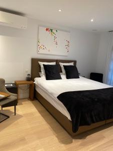 1 dormitorio con 1 cama con sábanas blancas y almohadas negras en 't pure genot, en Dilsen-Stokkem