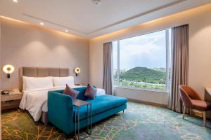 um quarto de hotel com uma cama e uma grande janela em Holiday Inn Katra Vaishno Devi, an IHG Hotel em Katra