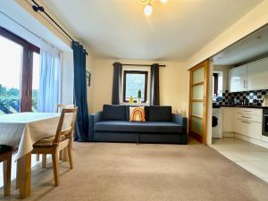 a living room with a blue couch and a kitchen at Super Apartment next to Bicester Village Sleeps 4 in Bicester
