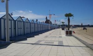 a sidewalk with a row of buildings on a beach at Meublé bord de Mer in Gravelines +4 photos