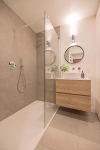 een badkamer met douche, wastafel en spiegel bij Mosselbank 211 in Nieuwpoort