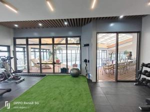 a room with a gym with a green carpet at 19F One Katipunan Residence in Manila