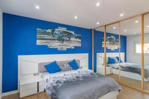 a bedroom with blue walls and a bed with blue pillows at APARTAMENTO HOLIDEA centro ciudad in Santander