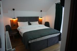 a bedroom with a large bed with a green blanket at Pensiunea Cascada in Borşa