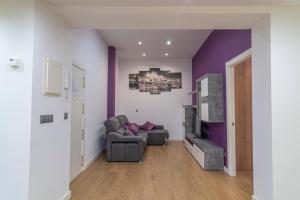 a living room with a couch and a tv at APARTAMENTO HOLIDEA centro ciudad in Santander