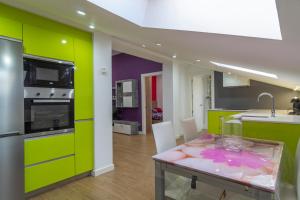a kitchen with lime green cabinets and a table with a sink at APARTAMENTO HOLIDEA centro ciudad in Santander
